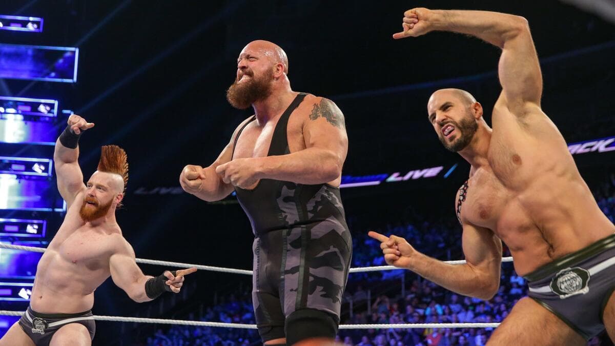 Cesaro and Sheamus pointing at The Big Show, who is flexing his muscles