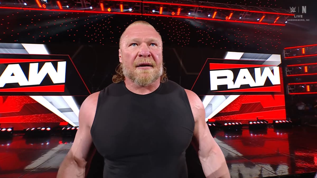 Brock Lesnar in a black vest in front of WWE Raw titantron