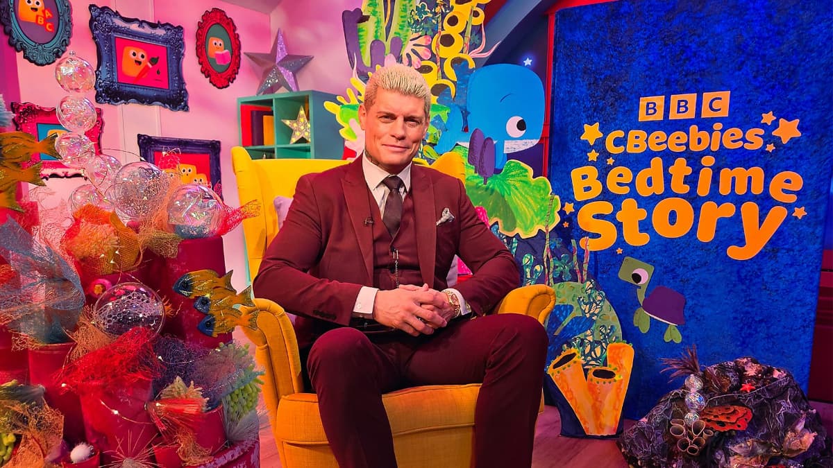 Cody Rhodes sitting in a chair on the set of CBeebies Bedtime Stories