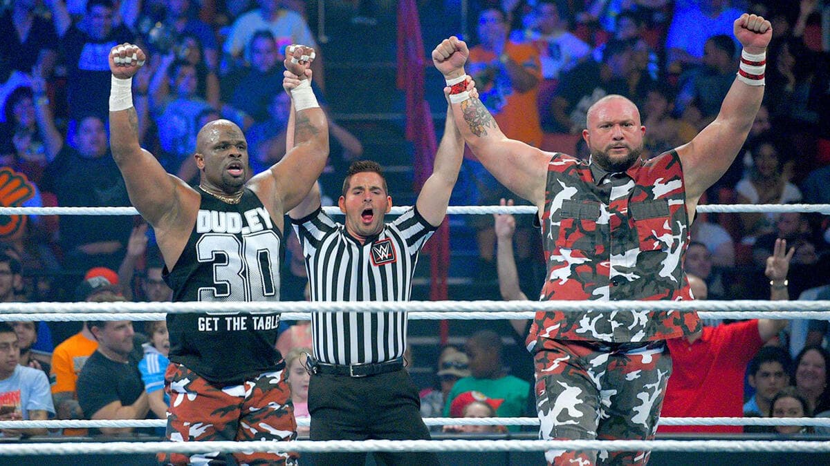 The Dudley Boyz have their arms raised by the referee following a victory on WWE SmackDown in 2015