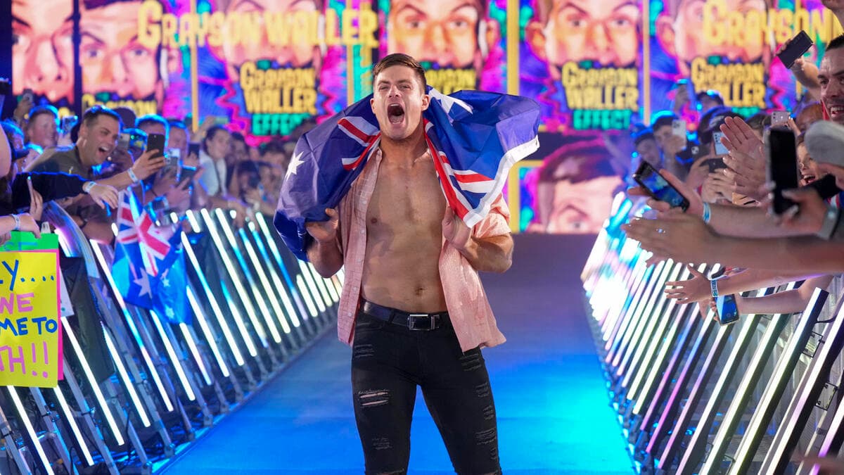 Grayson Waller walking to the ring with an Australian flag around his shoulders