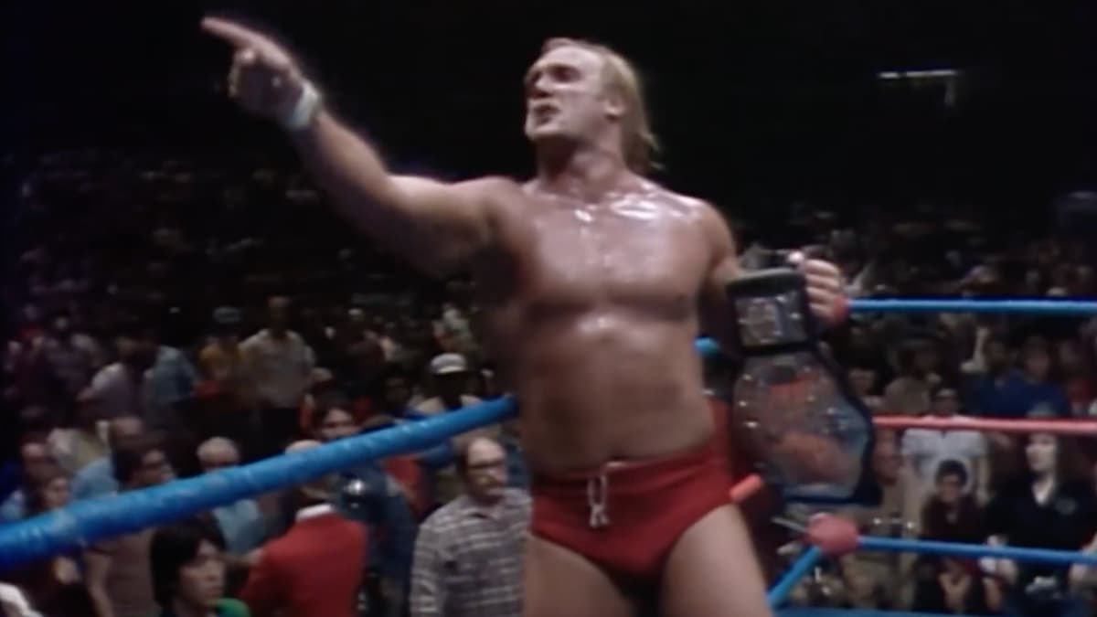Hulk Hogan pointing to the crowd while holding the AWA World Title at Super Sunday