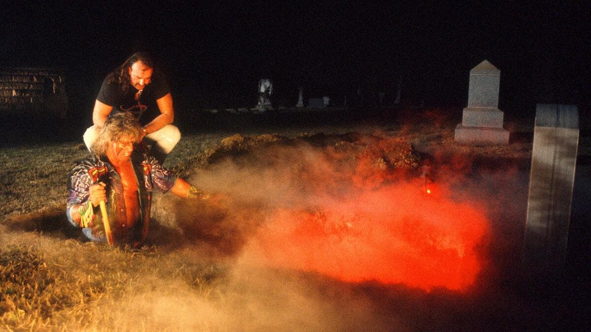 Jake Roberts forcing The Ultimate Warrior into a grave