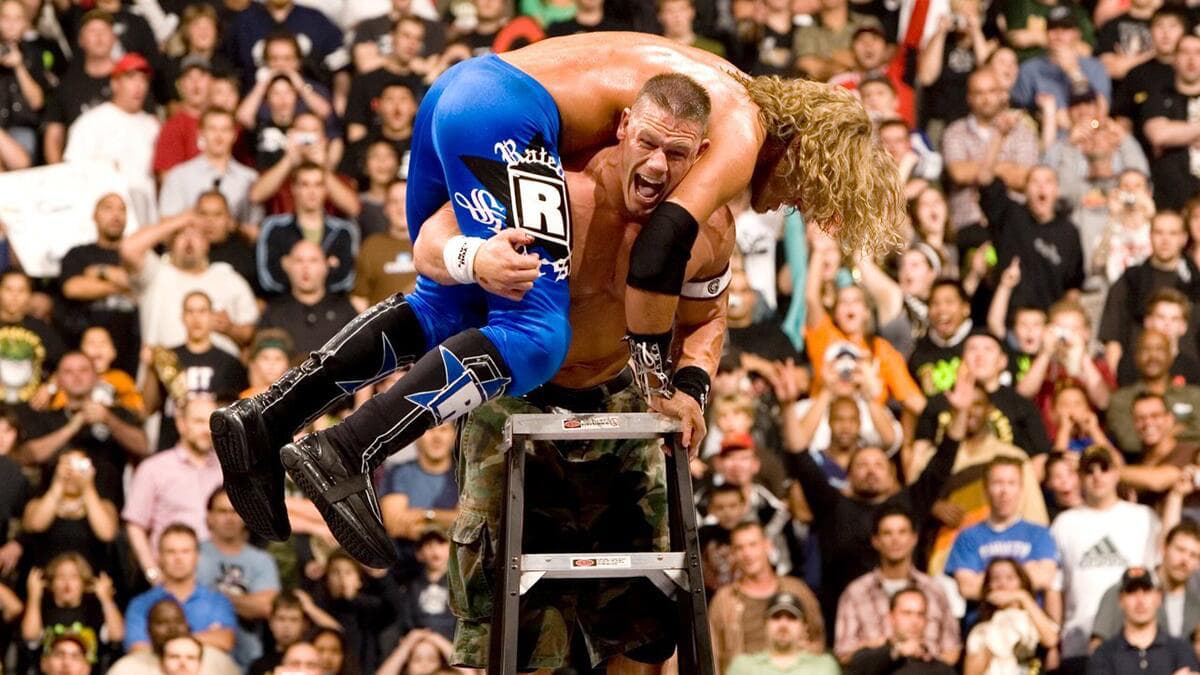 John Cena with Edge on his shoulders while on the top of a ladder at WWE Unforgiven 2006