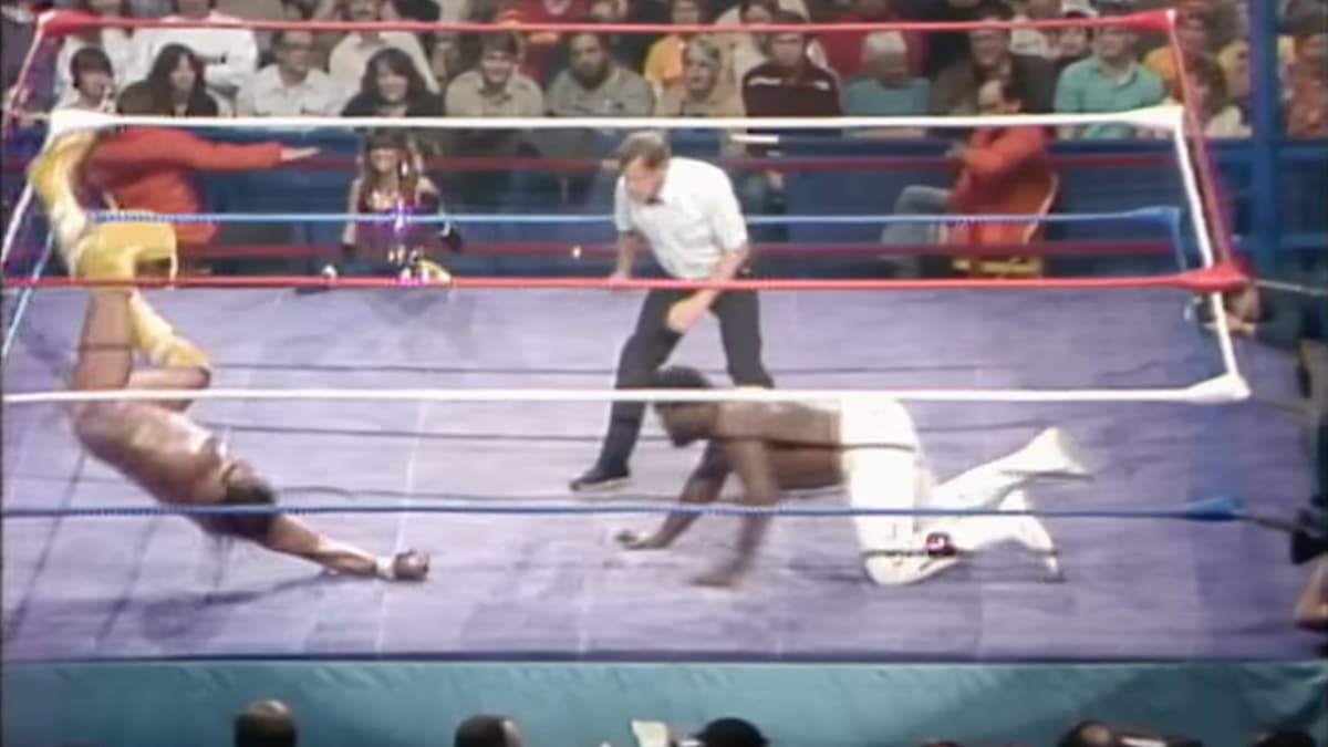 Randy Savage rolling away after a headbutt from Junkyard Dog at WWF The Wrestling Classic
