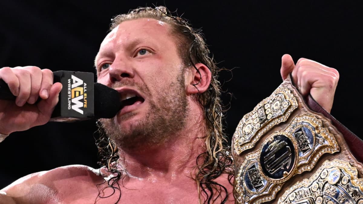 Kenny Omega cutting a promo while holding the AEW World Title