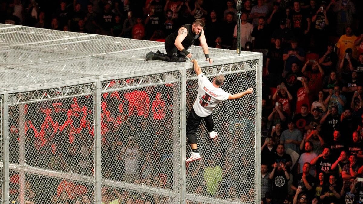 Kevin Owens on top of the cell as Shane McMahon hangs off the edge at WWE Hell in a Cell 2017