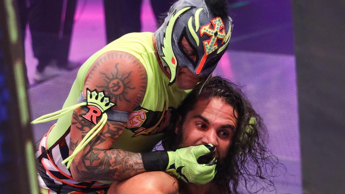 Rey Mysterio trying to force Seth Rollins' eye into the steel steps