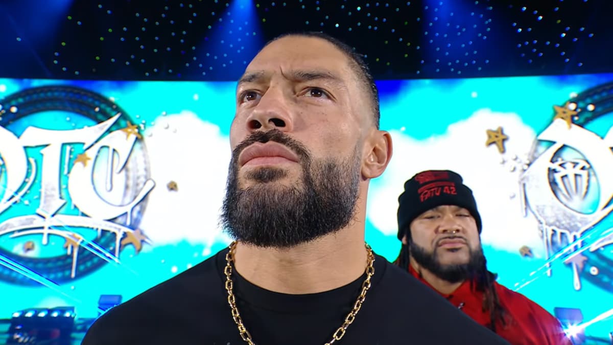 Roman Reigns looking up as Jacob Fatu looks down behind him