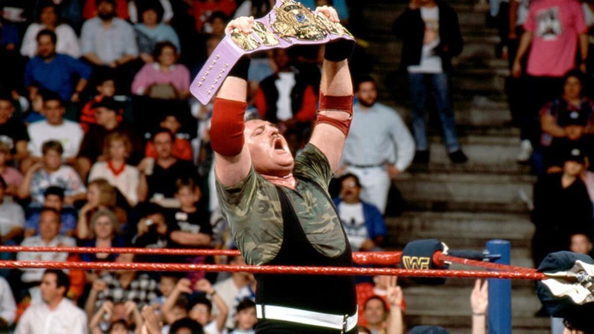 Sgt. Slaughter holding up a purple version of the Winged Eagle WWE Title belt