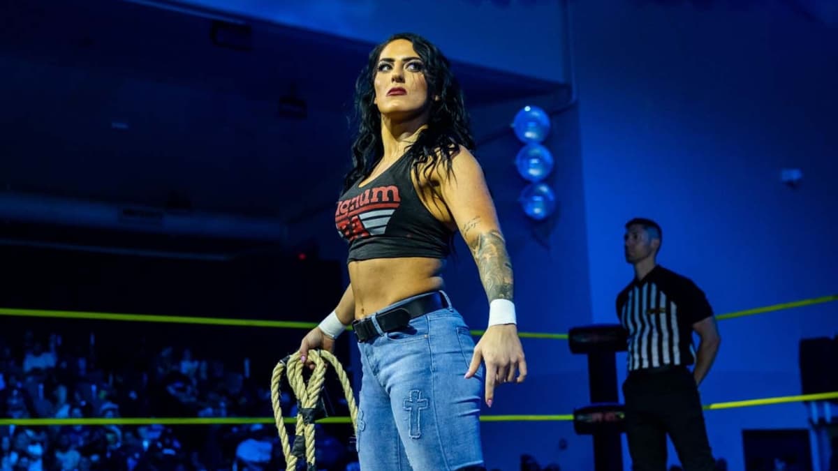 Tessa Blanchard holding a bull rope in jeans and a black vest