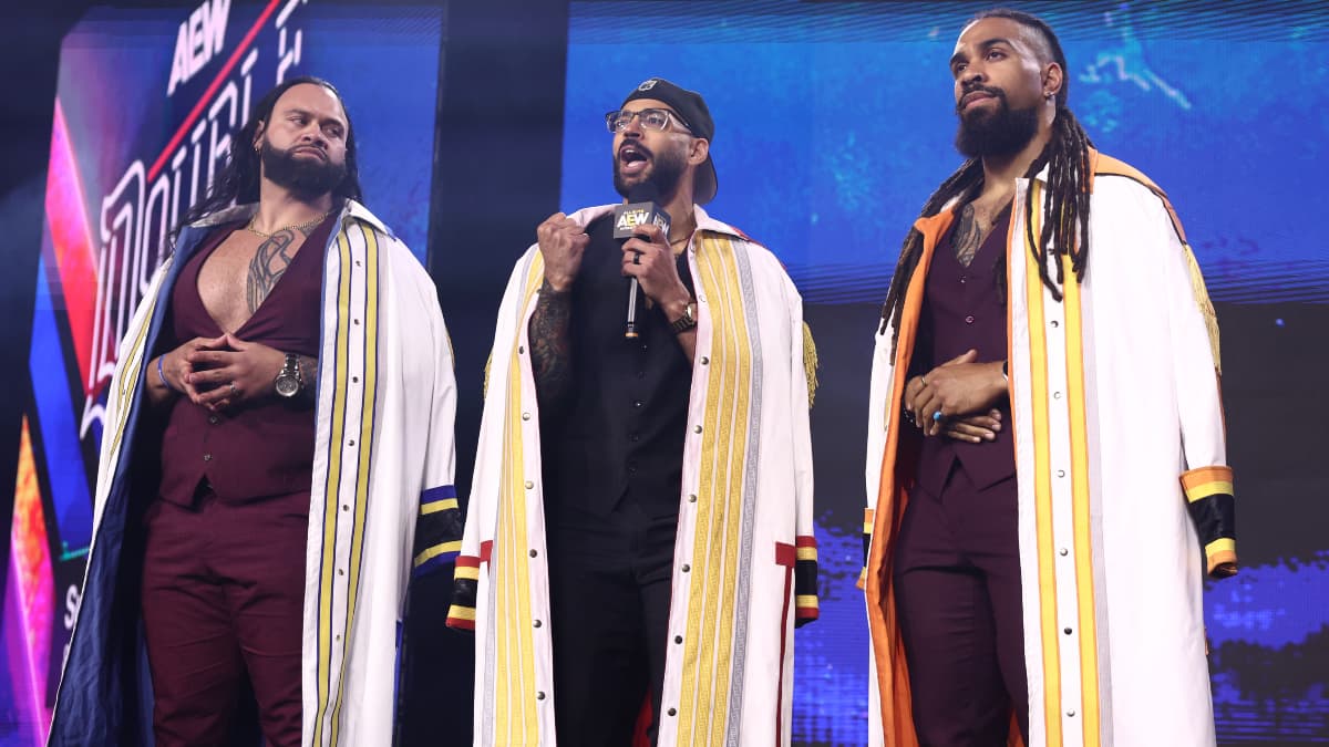 The Demand in long white coats and waistcoat vests in AEW