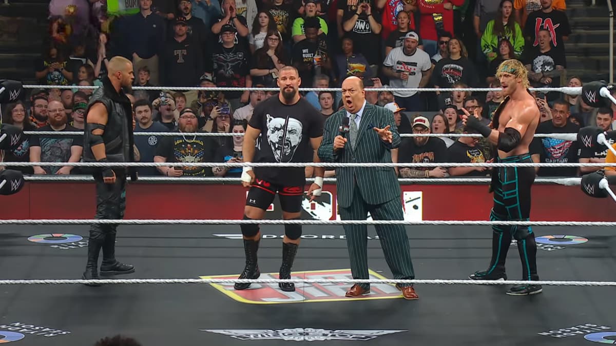 The Vision on May 2026 episode of WWE Raw standing in the ring as Paul Heyman cuts a promo wearing a pinstriped suit