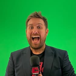 Tom Campbell smiling in front of a green screen