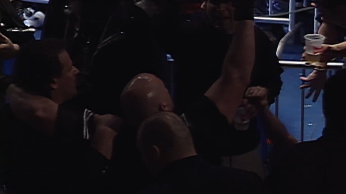 Vic Grimes raising his arm as he's held up by two men at ECW Living Dangerously 2000
