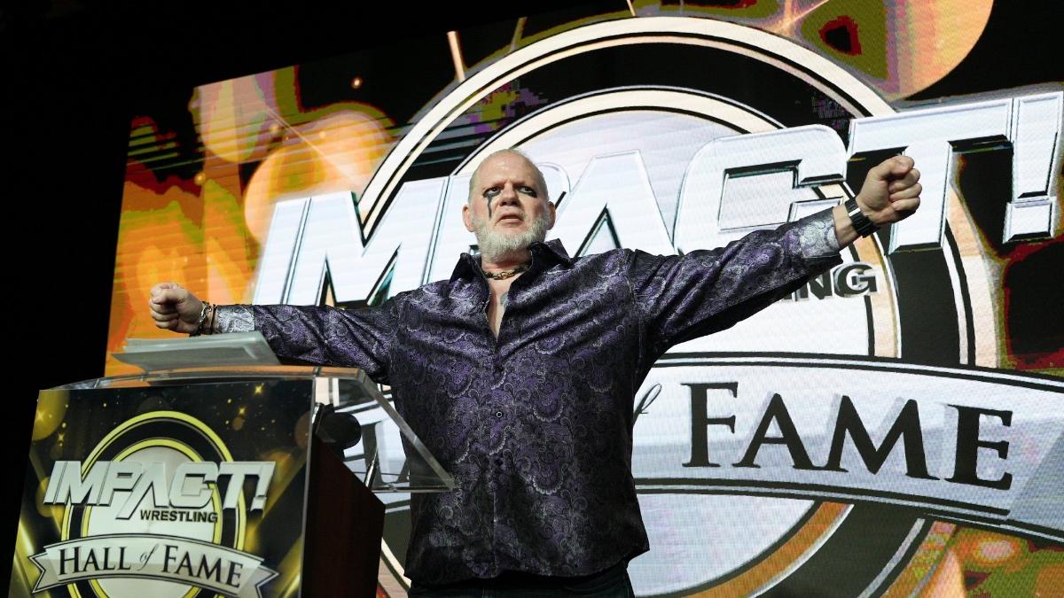 Raven with his signature arms outstretched post for IMPACT Hall of Fame induction in 2022