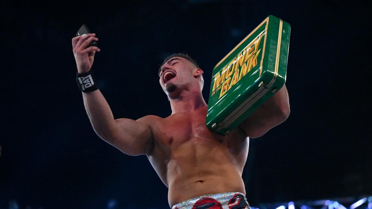 Austin Theory taking a selfie while holding the Money in the Bank briefcase at WWE Money in the Bank 2022