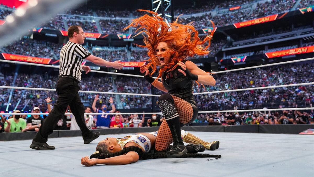 Becky Lynch celebrates as Bianca Belair lies next to her at WWE SummerSlam 2021