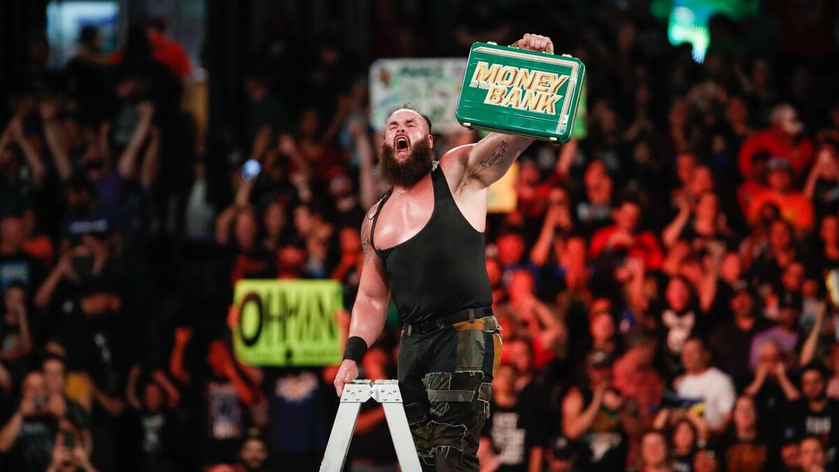 Braun Strowman on the top of a ladder holding a WWE Money in the Bank briefcase
