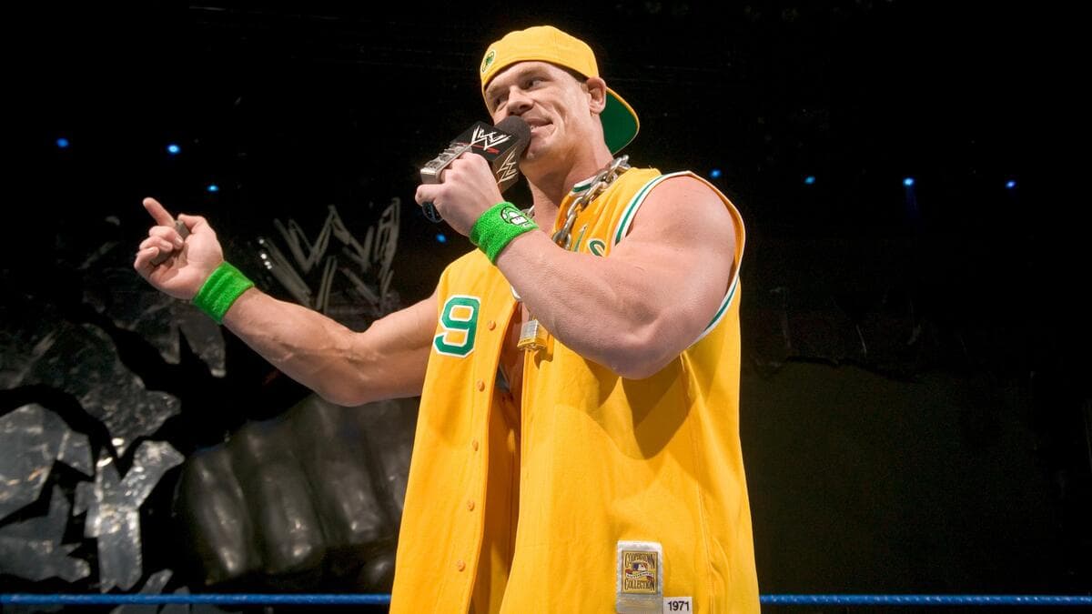 John Cena in a yellow vest and hat rapping on WWE SmackDown