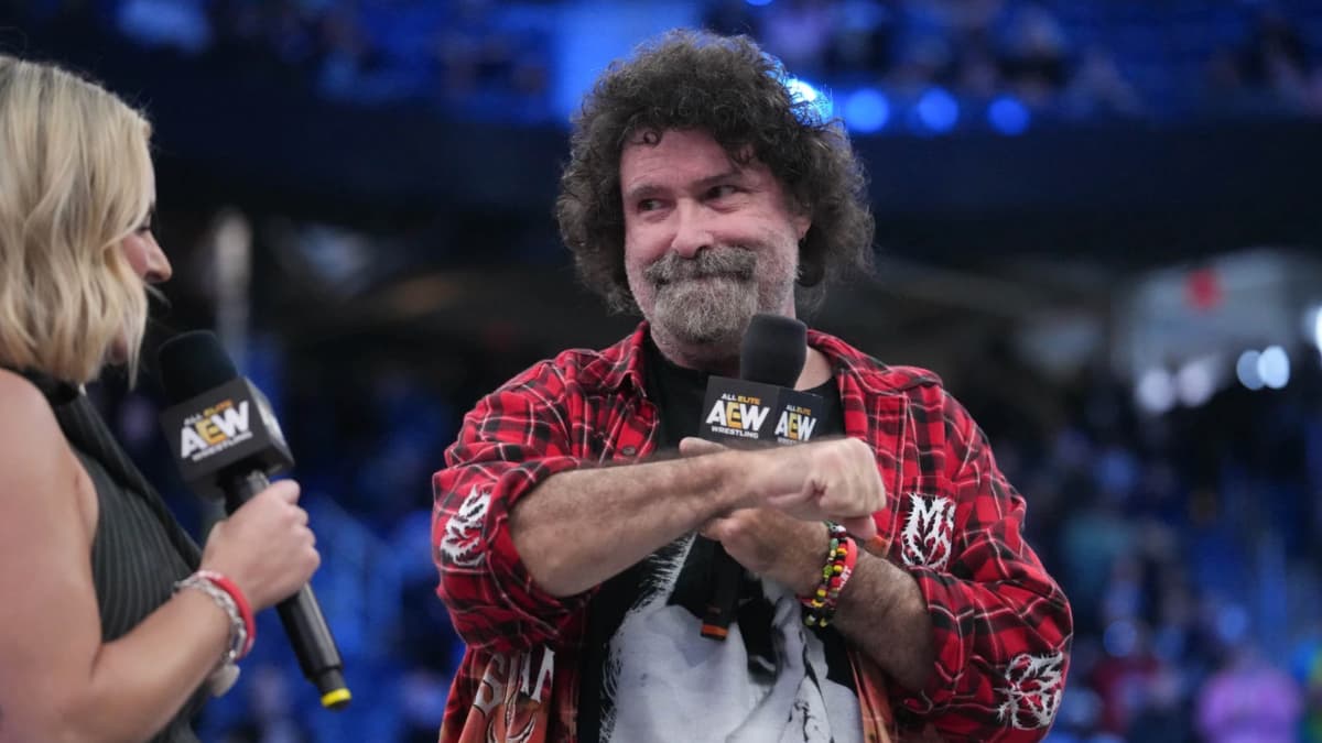 Mick Foley looking at his wrist in a red flannel shirt at AEW Double or Nothing 2026