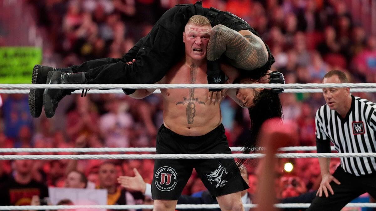 Brock Lesnar with Roman Reigns over his shoulders at WWE WrestleMania 31
