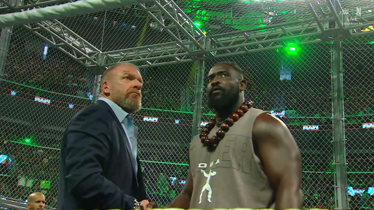 Oba Femi and Triple H shaking hands inside Hell in a Cell on WWE Raw