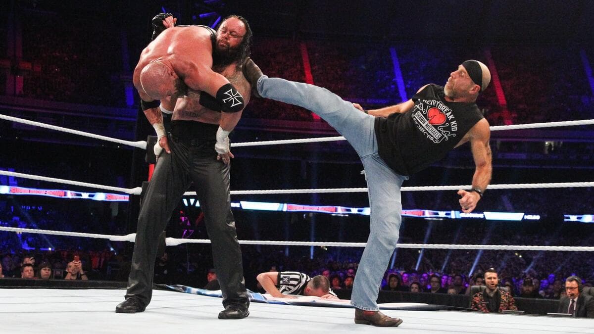 Shawn Michaels hitting The Undertaker with a superkick as Triple H is over Undertaker's shoulders