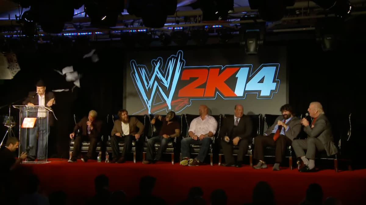 Panel of WWE legends sitting on a stage in front of a WWE 2k14 logo
