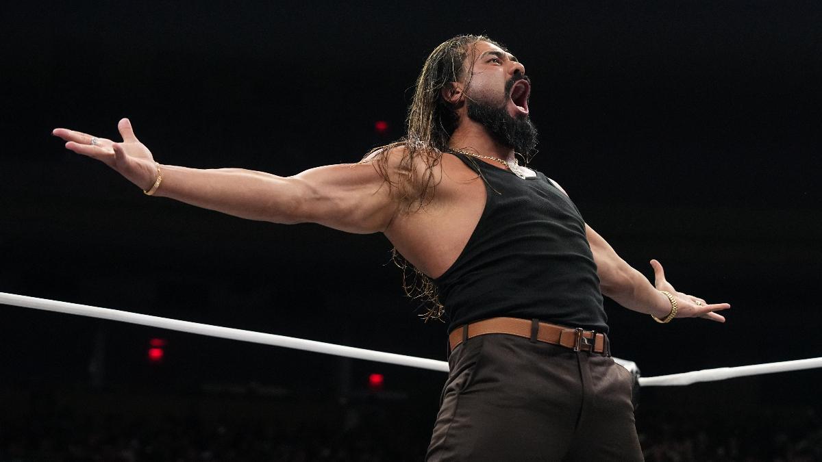 Andrade el Idolo with his arms outstretched roars in an AEW wrestling ring