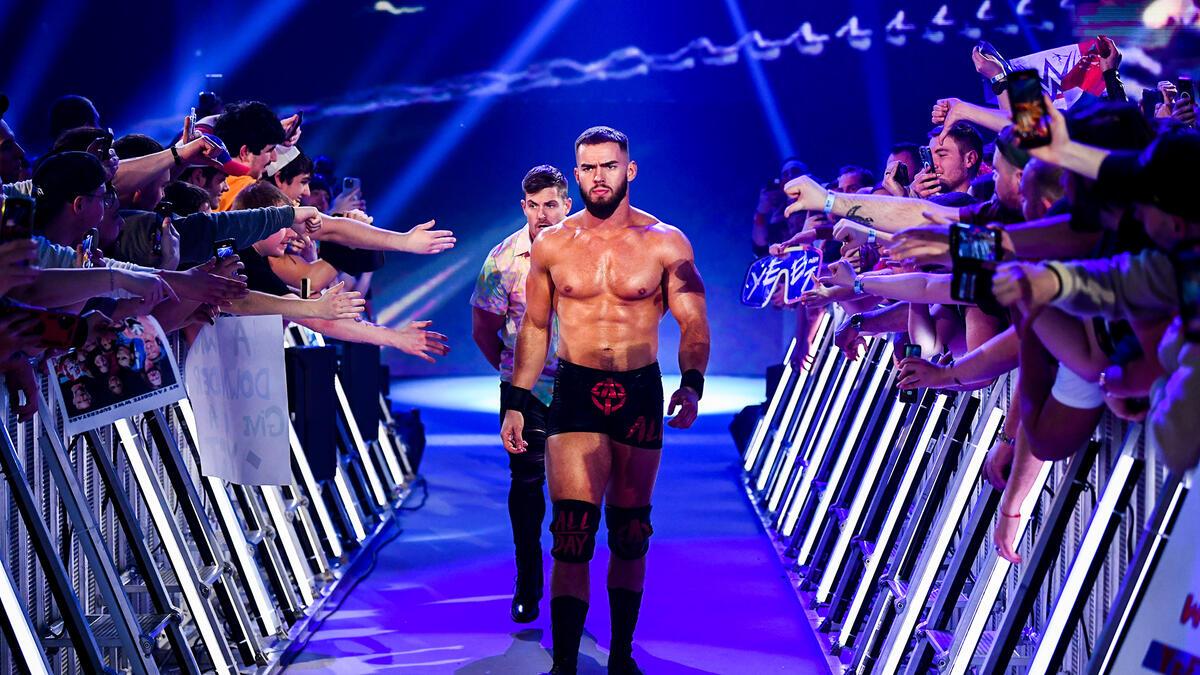 Austin Theory walking to the ring with Grayson Waller behind him