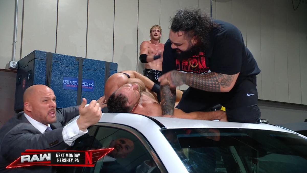 Bronson Reed pointing at LA Knight while lying on top of a car