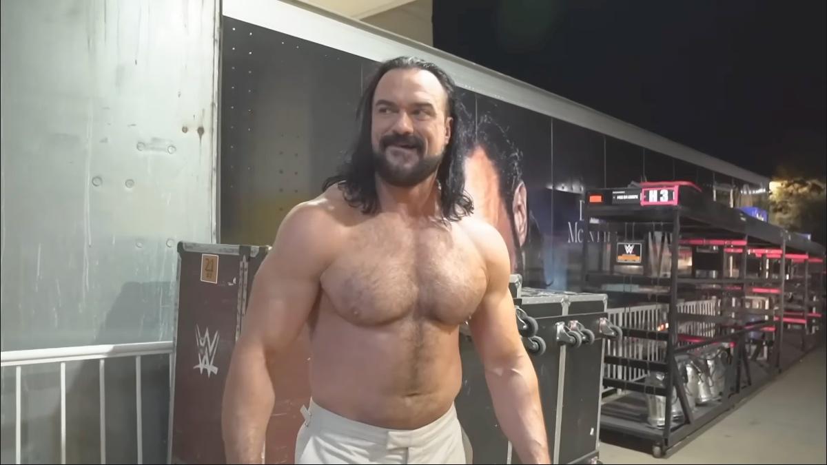 Drew McIntyre smiling in white trousers