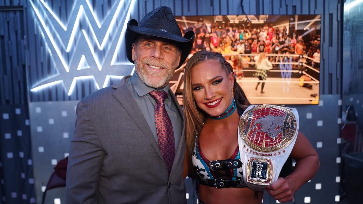 Fallon Henley posing for a photo with Shawn Michaels while holding the NXT Women's North American Title