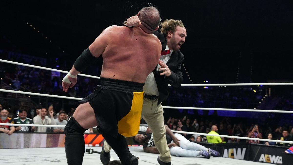 Hangman Page dressed as Tony Schiavone hitting a Buckshot Lariat to Samoa Joe