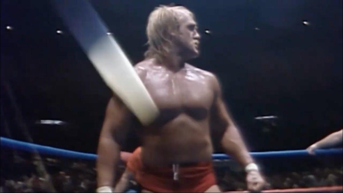 Hulk Hogan in red drunks looking around the ring in dismay as a projectile flies into the ring
