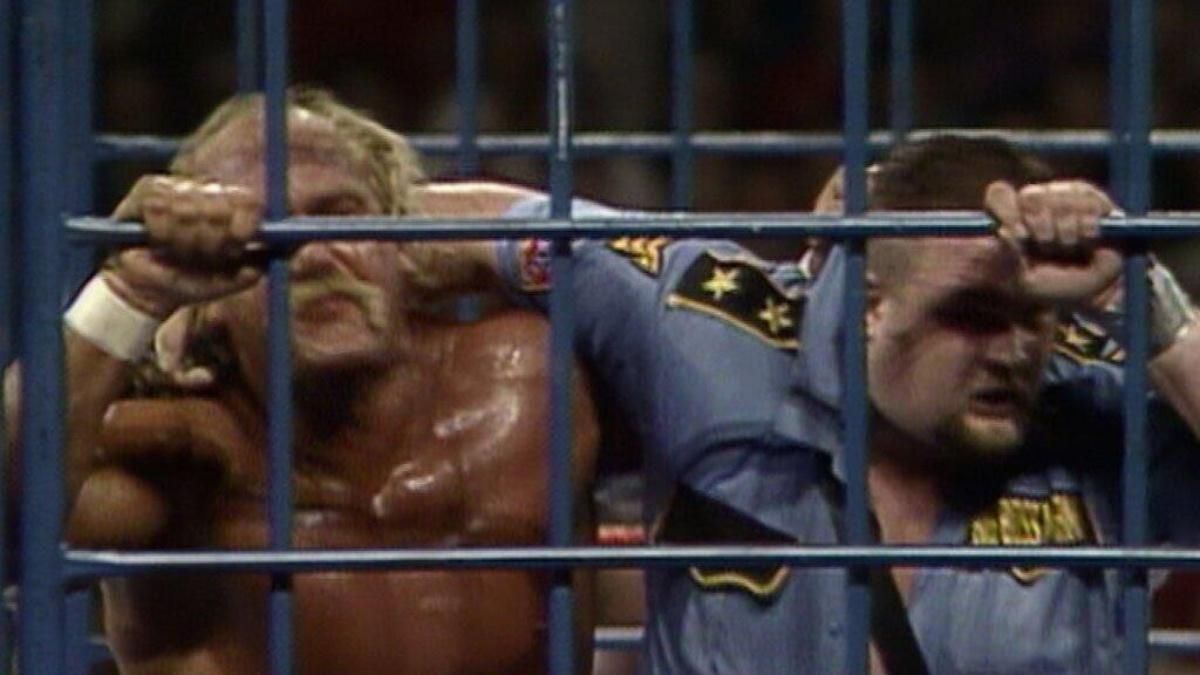 Hulk Hogan and The Big Boss Man sweating while struggling against the blue steel cage