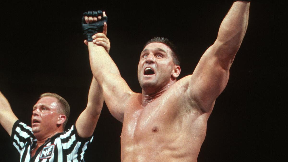 Ken Shamrock with his arm raised by referee Mike Chioda following his win at WWE King of the Ring 1998