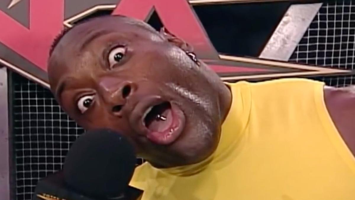 Monty Brown with his head at an angle wearing a yellow t-shirt