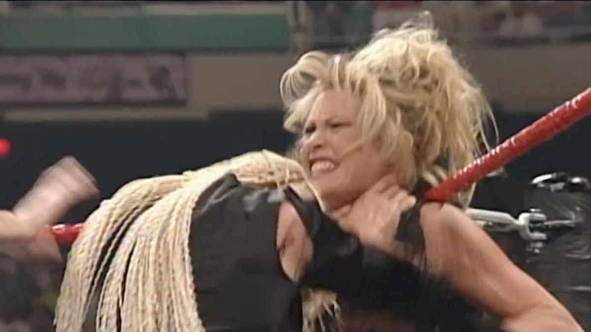 Sable being choked by Luna Vachon in the corner of a pro wrestling ring at WWE Unforgiven 1998