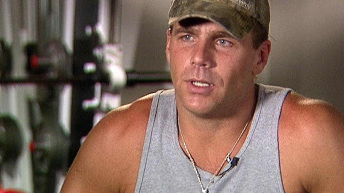 Shawn Michaels wearing a camouflage cap and grey vest