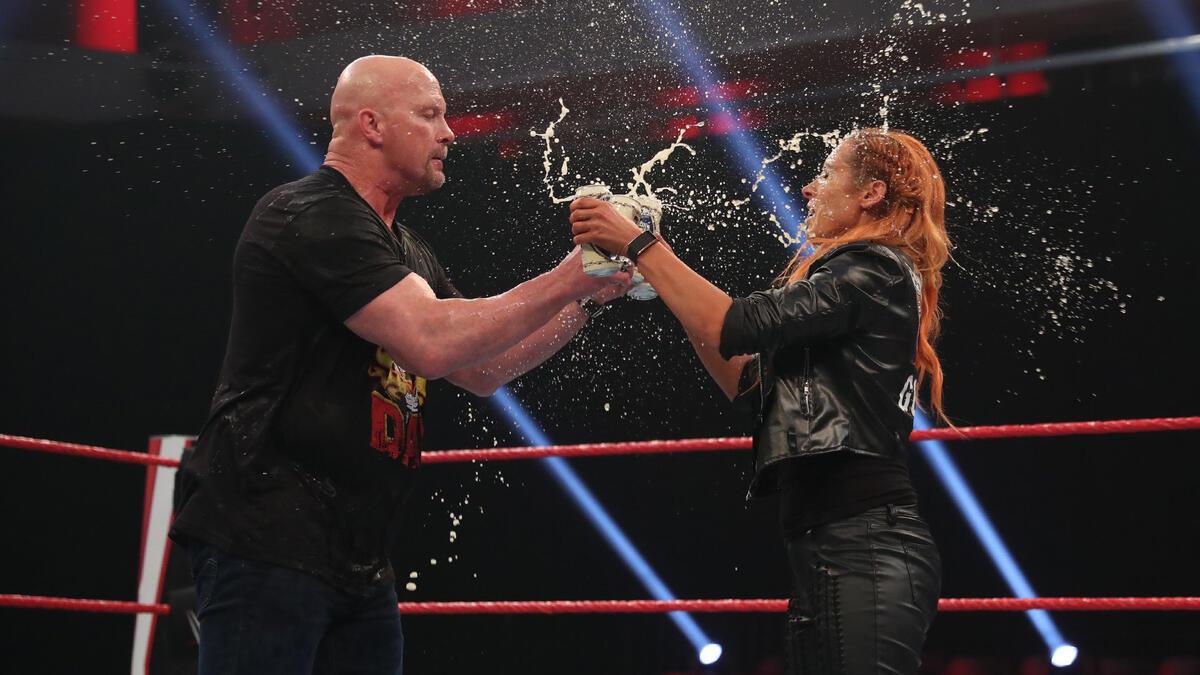 Steve Austin and Becky Lynch smashing beer cans together