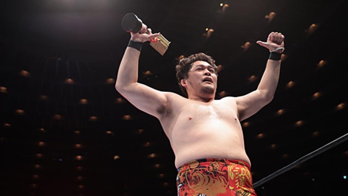 Toru Yano with his thumbs up and holding the KOPW trophy inside the Tokyo Dome