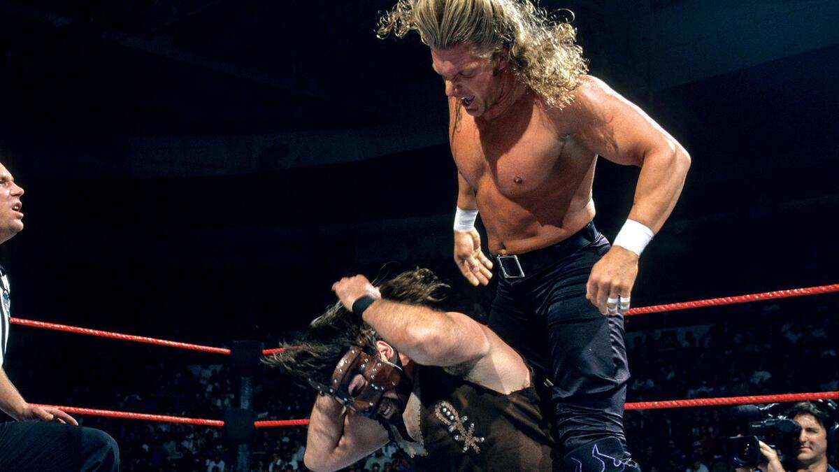 Triple H standing above a seat Mankind shouting at him at WWE King of the Ring 1997