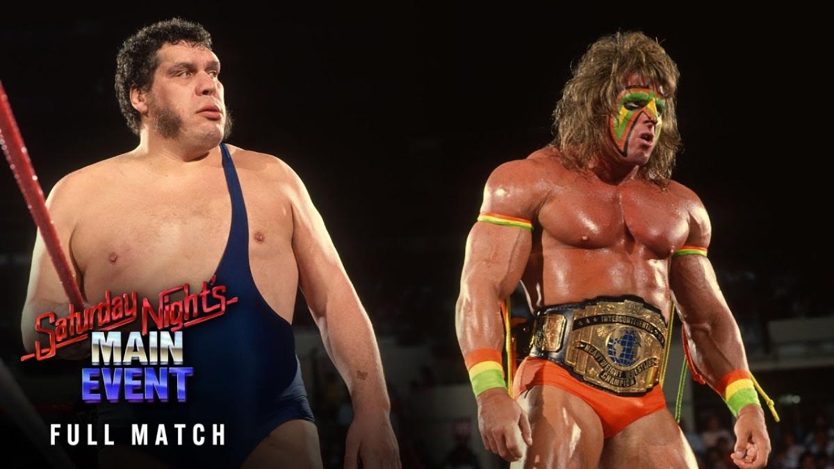 Andre The Giant looking at Ultimate Warrior, who has his back turned in the ring