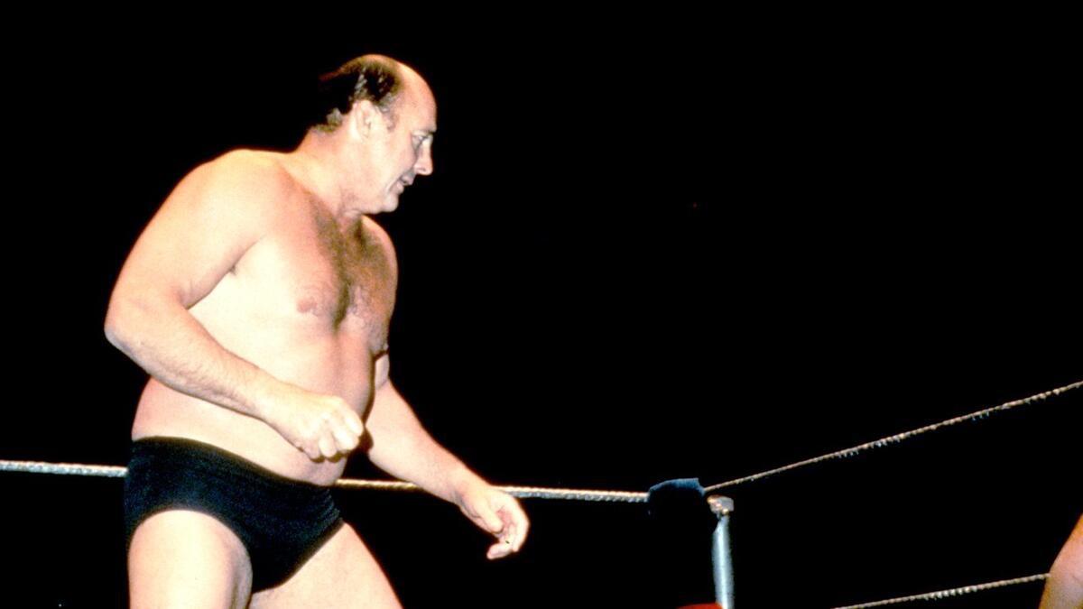Verne Gagne looking across the pro wrestling ring wearing black trunks